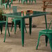 A green table and chair on an outdoor patio.