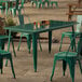 An emerald green Lancaster Table and Seating outdoor table and chair.