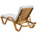 A Lancaster Table & Seating white resin chaise lounge with white cushion and pillow.