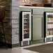 A dual temperature full glass door commercial wine cooler with multiple shelves for wine storage, built into a kitchen cabinet.