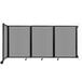 A light gray Versare wall-mounted room divider with black trim on wheels.