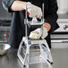 A person using a Vollrath Redco InstaCut 3.5 fruit and vegetable dicer to cut onions.