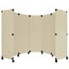 A beige rectangular Versare portable partition with black wheels.