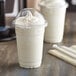 Two Choice clear plastic cups with white liquid and a dome lid.