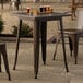 A Lancaster Table & Seating copper table on an outdoor patio with a tray of drinks on it.