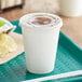 A white plastic Choice cold cup with a lid on a tray.