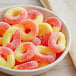 A white bowl filled with Albanese Gummi Peach Rings.