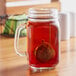A glass jar with a Choice stainless steel tea strainer in it.