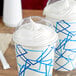 A close-up of two translucent dome lids on cups of frozen yogurt.