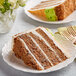 A slice of David's Cookies carrot cake on a plate with a fork.