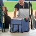 A man with a beard opening a Choice navy cooler bag filled with cans of beer.