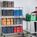 A woman standing next to a navy Choice large insulated cooler bag on a metal shelf.