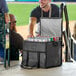 A man holding a Choice black insulated cooler bag with cans in it.