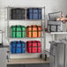 A woman standing in front of a shelf with green Choice insulated cooler bags with black straps.
