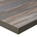 A BFM Seating chestnut wood rectangular table top with matching edge on a table.