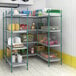 A Regency green wire shelving unit in a pantry filled with food.