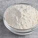 A glass bowl filled with unbleached enriched artisan bread flour.