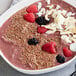 A bowl of pink smoothie with berries and Bob's Red Mill gluten-free flax seeds.