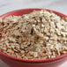 A bowl of Bob's Red Mill whole grain rolled oat flakes on a table.