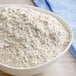 A bowl of Bob's Red Mill whole wheat pastry flour on a table.