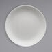 A close up of a Fortessa Caldera bright white coupe china plate.