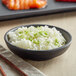A bowl of rice with a pair of chopsticks.