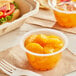 A plastic cup of Premium Mandarin Oranges in natural juice on a table.