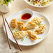 A white GET Enterprises Riverstone melamine plate with fried dumplings and chopsticks.