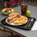 A Carlisle fast food tray with a sandwich and chips on it.