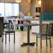 A Lancaster Table & Seating white birch and ash laminated table top on a table in a restaurant dining area.