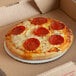 A pepperoni pizza on a 6" white corrugated cardboard pizza circle in a box.