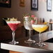 Arcoroc Broadway Gin and Tonic glasses with red and yellow cocktails on a bar counter.