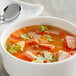A bowl of soup with ham and vegetables made with Goya Ham Flavor Concentrate.