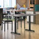 A Lancaster Table & Seating rectangular reversible white and gray slate laminated table top on a table in a restaurant with chairs.