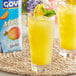 A glass of Goya Mango Nectar with fruit on a stick.