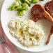 A plate of food with a piece of meat and Idahoan Rustic Baby Reds mashed potatoes.