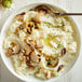 A bowl of Idahoan mashed potatoes with mushrooms and a spoon.