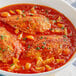 A bowl of chicken stew with yuca harina in white sauce.