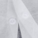 A close up of a white fabric lab coat with buttons.