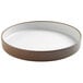 A white stoneware raised rim melamine plate with brown edges.