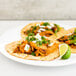 A plate of three tacos with Upton's Naturals Jackfruit with lime wedges.