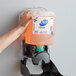 A hand holding a Dial foaming hand soap dispenser.