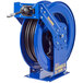 A blue Coxreels truck mount hose reel with a black hose attached.
