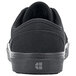 A black Shoes For Crews Merlin non-slip shoe with a logo on the side.