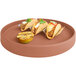 A Cal-Mil terra cotta melamine plate with tacos, fruit, and a lemon half.