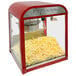 A red and silver Paragon 1951 Diner Popcorn Machine filled with popcorn.