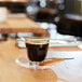 An Arcoroc old fashioned glass of coffee on a table with a cookie and spoon.