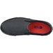 A black Shoes For Crews Ollie II non-slip casual shoe with a red sole.