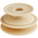 A close-up of a beige plastic circular pulley with a hole in the center.