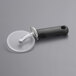 An OXO pizza cutter with a plastic handle and thumb guard.